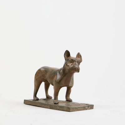 statue d'un bouledogue français posée sur un socle en marbre
