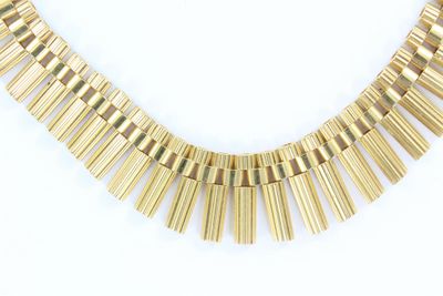 gros plan d'un collier en or sur fond blanc