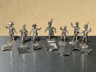 a lot of silver figurines of soldiers on a table