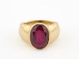 une bague en or avec une pierre rouge au centre