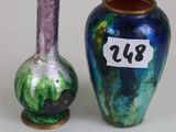 two vases sitting next to each other on a white surface