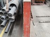 un gros tas de tuyaux en acier entreposés dans un entrepôt
