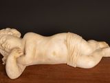 an image of a statue of a baby laying down on a table