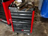 une boîte à outils rouge sur laquelle sont posés des outils, dans un garage