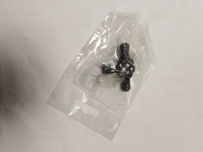 un petit objet noir dans un sac en plastique posé sur une surface blanche