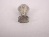 a small silver object on a white surface