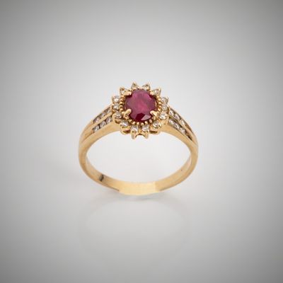 a gold ring with a ruby stone surrounded by diamonds