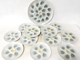many white plates with yellow flowers on them on a table