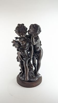 une image représentant une statue de deux enfants avec un panier de fleurs