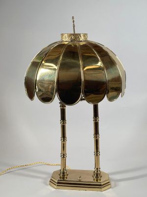 une lampe de table en laiton surmontée d'un abat-jour en laiton