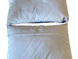 pair of two white pillows sitting on top of each other on a white surface