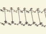 six pairs of hooks hang on a wall in a row