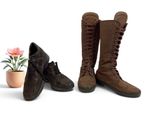 two pairs of boots that are next to a potted plant