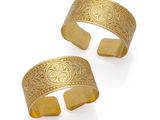 a pair of gold cuff bracelets with engraved designs