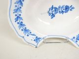 a blue and white plate with a flower design on it