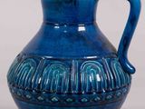 a blue vase with a handle sitting on a table
