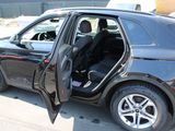 a black car with its door open in a parking lot