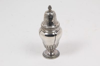a silver salt shaker on a white table