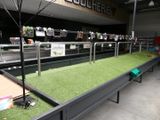 une longue table recouverte d'herbe dans un magasin