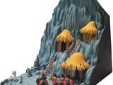 figurines of people in front of a mountain with thatched huts