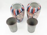 two vases sitting next to each other on a white surface