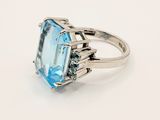an image of a ring with a blue topazr stone surrounded by diamonds