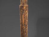 a tall wooden pole with a carved head on top of it
