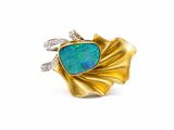 un gros plan d'une bague en or sertie d'une opale bleue et de diamants