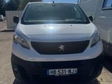 La camionnette blanche est garée sur le parking, à côté d'une autre camionnette blanche.