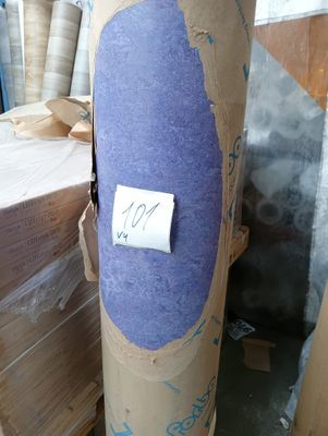 a large roll of paper on the ground next to a pile of boxes