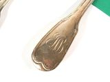 two spoons and a fork on a green and white table
