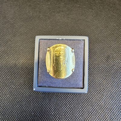 une photo d'une bague en or dans un écrin posé sur une table