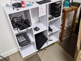 a white shelving with many items on it in a room