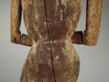 a wooden statue of a woman holding a knife in her right hand