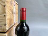 a bottle of red wine sitting next to a wooden box
