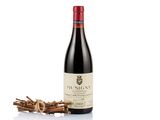 a bottle of wine sitting next to a bunch of sticks