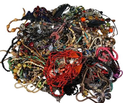 a pile of assorted bracelets and necklaces on a white surface