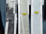 many mattresses stacked up on a pallet outside a building
