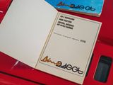 a book open on a red table with a cell phone on it