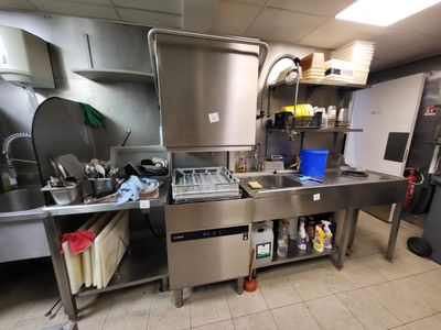 une grande cuisine en inox équipée d'un évier et d'une cuisinière