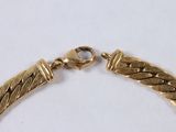 gold plated bracelet with braid design and clasp on a white surface