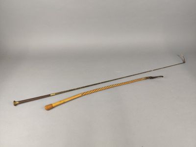 une vieille canne à pêche avec un manche en bois posée sur une surface blanche