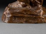 a bronze statue of a dog sitting on a rock