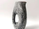 un vase noir et blanc percé d'un trou