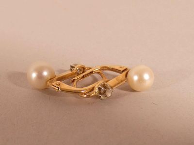 a close up of a pearl and gold ring on a white surface