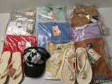 several pairs of flip flops, a hat, and other clothing are on a table