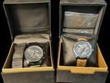 pair of two watches in a box on a black surface