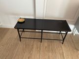 a small black table with a bowl of fruit on it