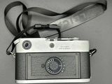 a black and white photo of a camera with a strap