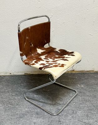 a chair with a cow print seat and a metal frame